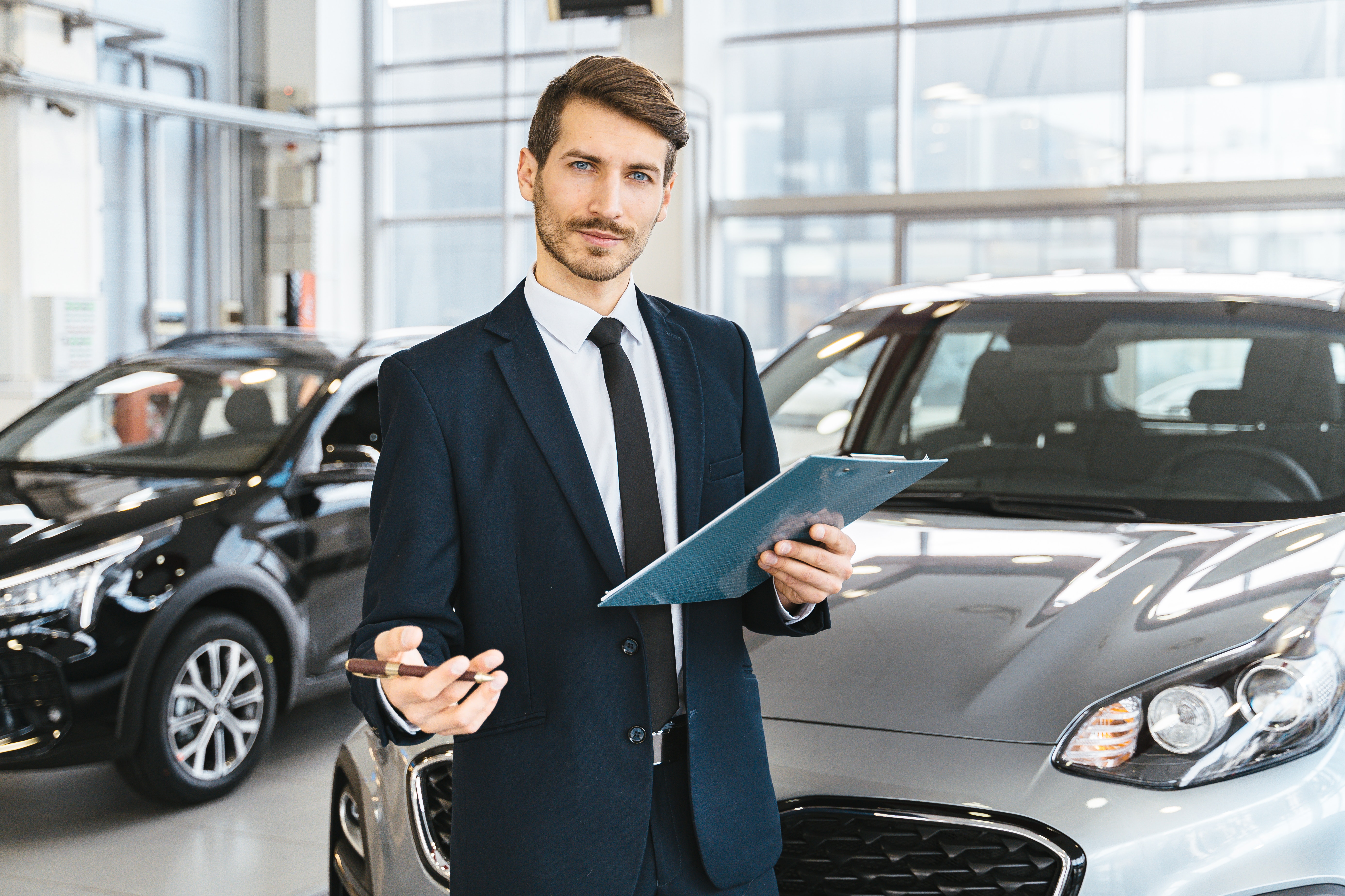 a man at a dealership holding a clipboard