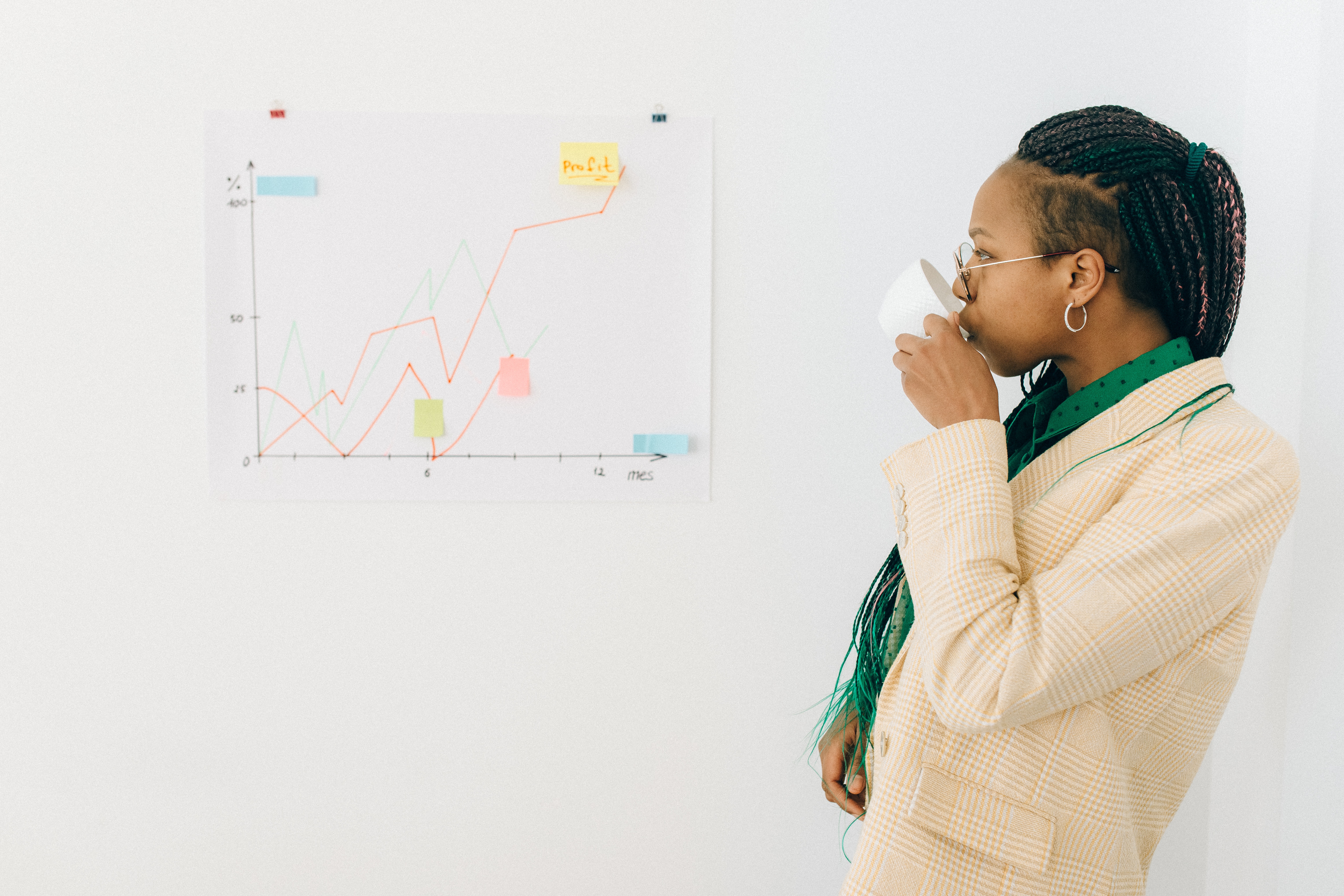 a woman sipping coffee while looking at a chart